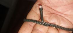 Zbliżenie ręki trzymającej zielony kabel z diodą LED