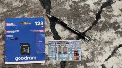 Packaging of a Goodram 128GB microSD card, a pen with the inscription elektroda.com, and a card with connector labels on a carpet.
