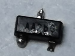 Mały element SMD w obudowie SOT-23 z napisem AA2bG, wylutowany z płytki.