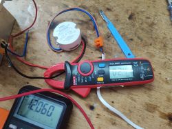 Multimetr i zasilacz IP67 na drewnianym stole.