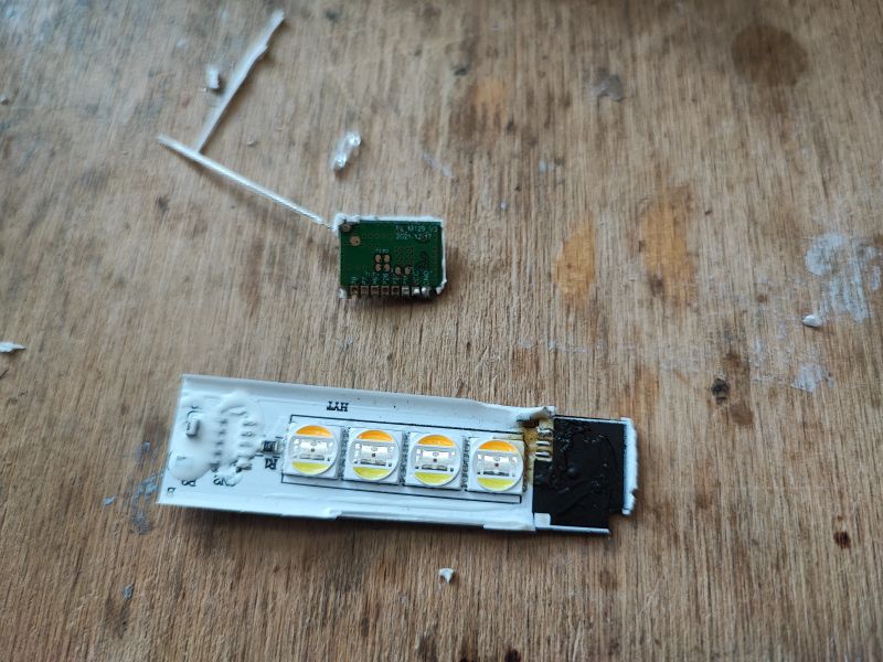 Dismantled smart lamp with WiFi module and LED board WiFi module and LED board on a wooden surface.