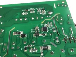 Zbliżenie na spód płytki PCB z widocznymi elementami SMD oraz ścieżkami miedzianymi.