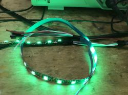 Connected Green LED Strip Green LED strip connected to a device on a wooden table.