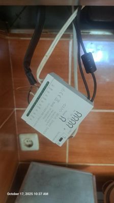 Sonoff smart control module with wiring installed Sonoff relay module with connected wires in a kitchen setting