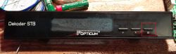 Front panel of Opticum STB decoder with power button highlighted in red