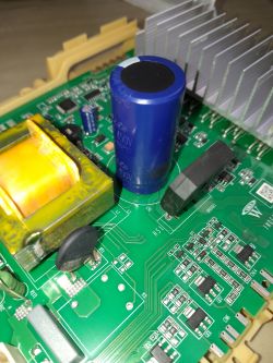 Widok zbliżony na obwód elektroniczny z kondensatorem i radiatorem.