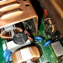 Zbliżenie na wnętrze ładowarki samochodowej Lead ABC 2430 z widocznymi elementami elektronicznymi, w tym element oznaczony jako R18, który jest zwęglony.