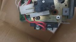 Widok zbliżony elementu elektronicznego z czerwonymi przewodami i złączem.