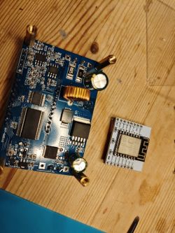 Electronic components on a wooden table: PCB board and WiFi module.