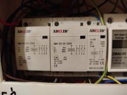 Zbliżenie na przekaźniki elektryczne marki Adelid zamontowane w panelu.