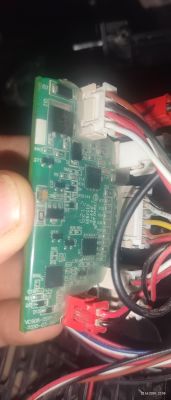 Zbliżenie na płytkę drukowaną z elementami elektronicznymi i podłączonymi przewodami.