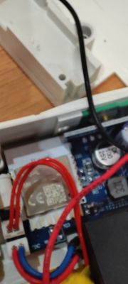 Inside view of smart relay with wires and communication module Close-up of smart relay interior with exposed circuit board and colored wires.