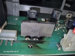 Spalony element elektroniczny na płytce drukowanej z widocznymi śladami przepalenia.