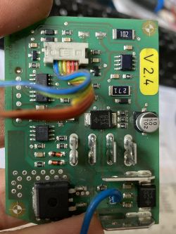 Nahaufnahme einer elektronischen Leiterplatte mit verschiedenen Bauteilen und der Beschriftung V24.