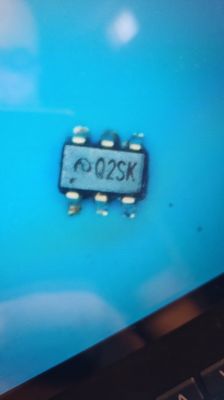 Close-up of an integrated circuit with Q2SK marking on a blue background.