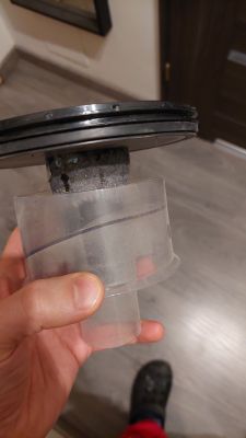 Część plastikowa odkurzacza Bosch, trzymana ręką, z widocznym filtrem pokrytym kurzem.