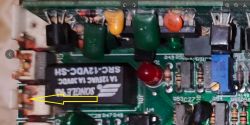 Zbliżenie na układ elektroniczny z przekaźnikiem Songle i śladami przebarwień.