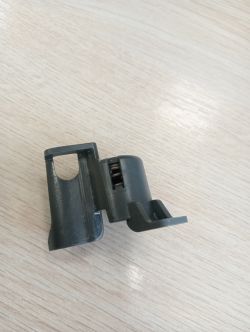 Plastikowa część leżąca na drewnianej powierzchni