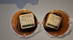 Two OXT “ZigBee roller shutter controller” modules in a double wall box, with terminals and wiring visible