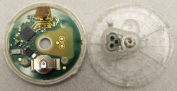 Disassembled electronic sensor with visible circuit board and 1.5V battery slot.