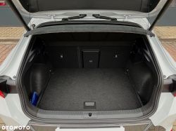 Open trunk of a white car with black carpeted lining and a parcel shelf