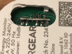 A part of an electronic device with a visible circuit board through a cutout in the casing.