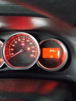 Zestaw wskaźników auta z podświetleniem na czerwono i świecącą kontrolką AdBlue oraz zasięgiem 320 km