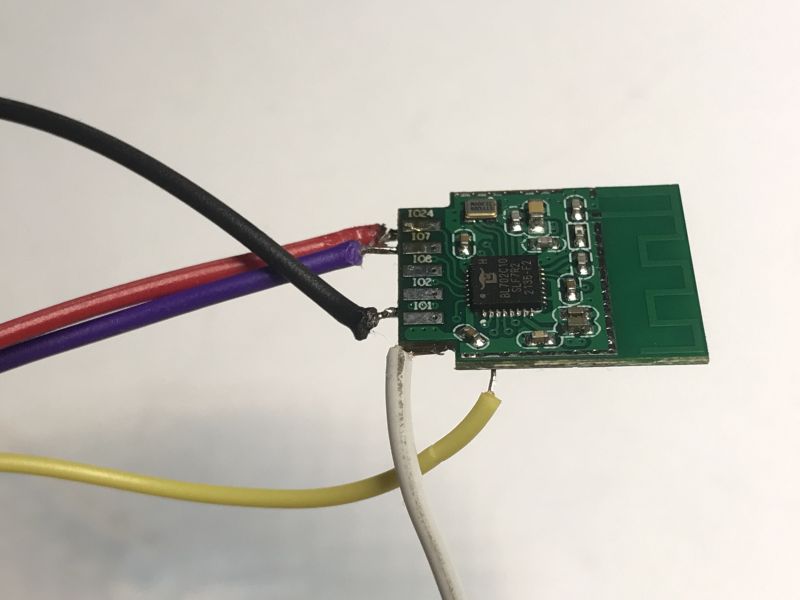Close-up of a small electronic module with soldered wires.