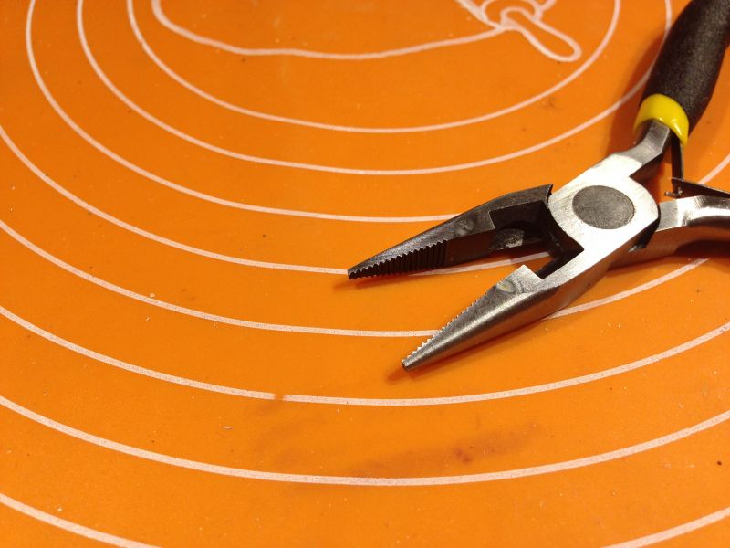 Kombinerki na pomarańczowej podkładce z białymi okręgami