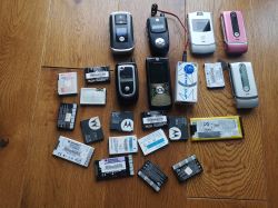 Stara kolekcja telefonów Motorola i akcesoria na drewnianej podłodze