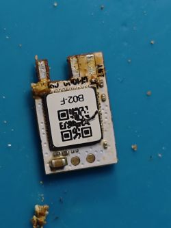 Sonoff B02-F Wi-Fi module with visible IC and QR code on white PCB, partially dirty with resin residue.