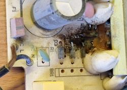 Damaged circuit board of GAL 18V-40 charger with visible signs of short circuit and damage.