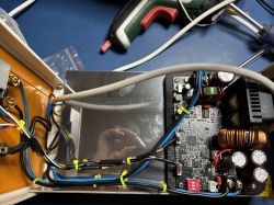 Inside a metal enclosure with an electronics module, cable ties, and a large copper inductor coil