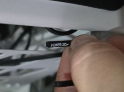 Zbliżenie na wtyczkę z napisem POWER LED- trzymaną między palcami