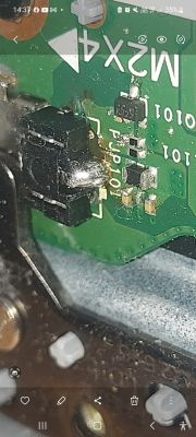 Zbliżenie płyty PCB z gniazdem zasilania i śladami przypalenia przy lutach
