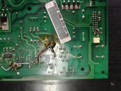 Spód zielonej płytki PCB z naklejką kodu kreskowego i śladami lutowania oraz przewodami w centrum
