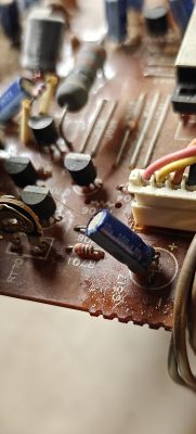 Zbliżenie na płytkę drukowaną starego magnetofonu Hitachi z kondensatorami elektrolitycznymi.