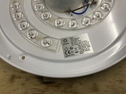Image of the interior of a round LED lamp showing LEDs and an informational sticker.