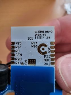 Close-up of an electronic module with port labels and codes.