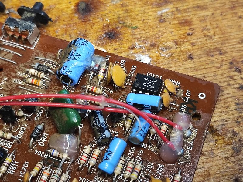 Zbliżenie na płytkę drukowaną telefonu stacjonarnego z widocznymi elementami elektronicznymi.