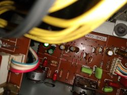 Wnętrze urządzenia elektronicznego z widocznym potencjometrem i innymi elementami elektronicznymi.