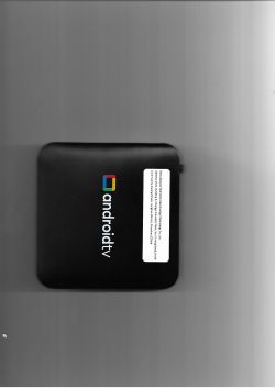 Czarna przystawka Android TV z kolorowym logo i białą etykietą producenta