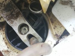 Wnętrze ekspresu do kawy z widocznymi metalowymi i plastikowymi elementami oraz śladami rdzy i zabrudzeń.