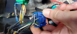 Zbliżenie na niebieską kostkę elektryczną z wieloma kolorowymi przewodami.