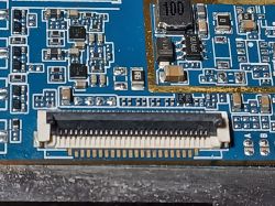 Zbliżenie na złącze FPC/FFC na niebieskiej płytce PCB z utlenionymi pinami