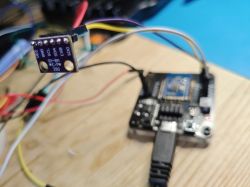 Close-up of a BME280 module connected to a microcontroller with colored wires.