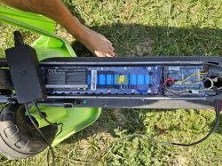 Widok wnętrza hulajnogi elektrycznej Mi M365 z wyeksponowanym akumulatorem i obwodami elektrycznymi.