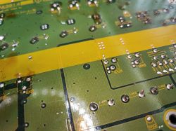 Zdjęcie płytki PCB z widocznymi lutami i oznaczeniami elementów.