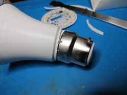 Disassembled LED bulb on blue surface Disassembled LED bulb with metal base and internal parts on blue background
