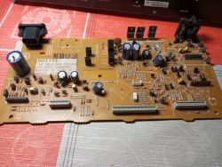Płytka drukowana z komponentami elektronicznymi leżąca na czerwonym tle.